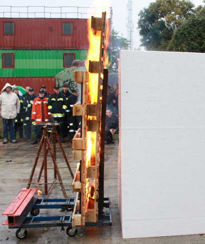 Obrázek: Hořící dřevěné palety před blokem EPS